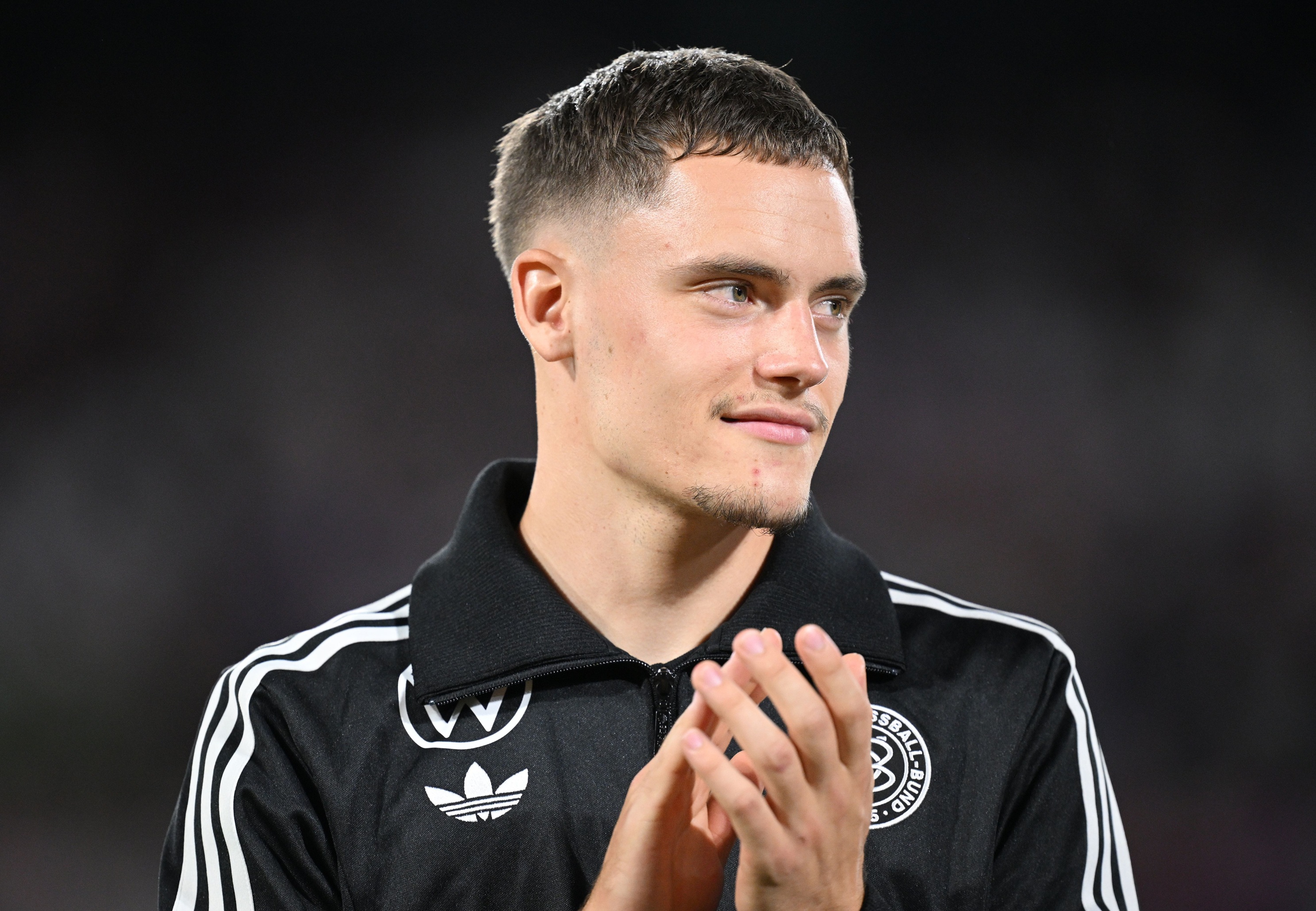 Florian Wirtz claps his hands and looks to his left.