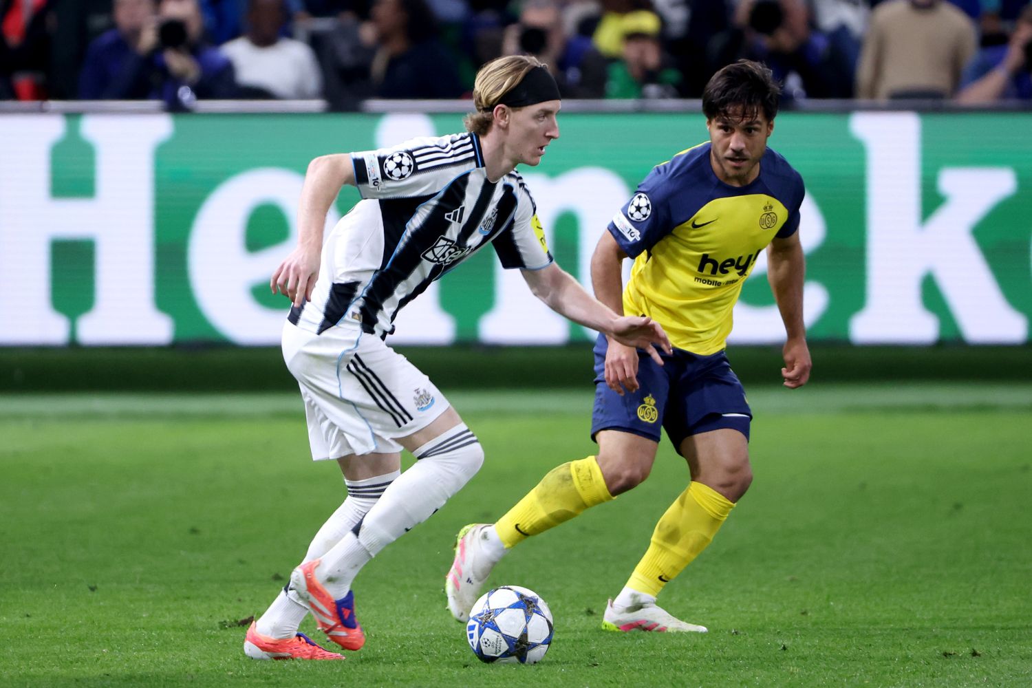Anthony Gordon of Newcastle United is put under pressure by Kevin Mac Allister of R. Union Saint-Gilloise
