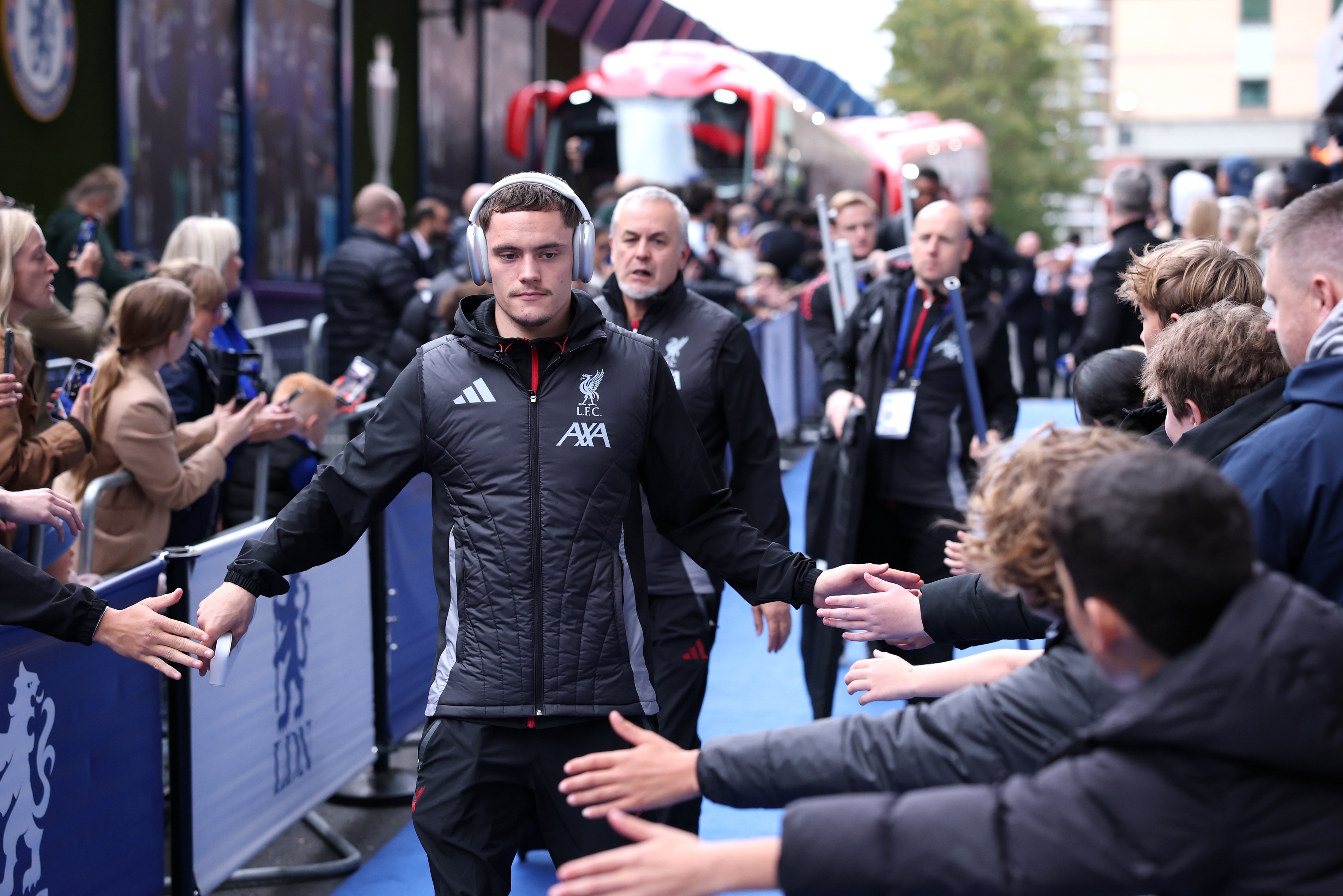 Florian Wirtz holds his hands out to football fans outside Stamford Bridge.