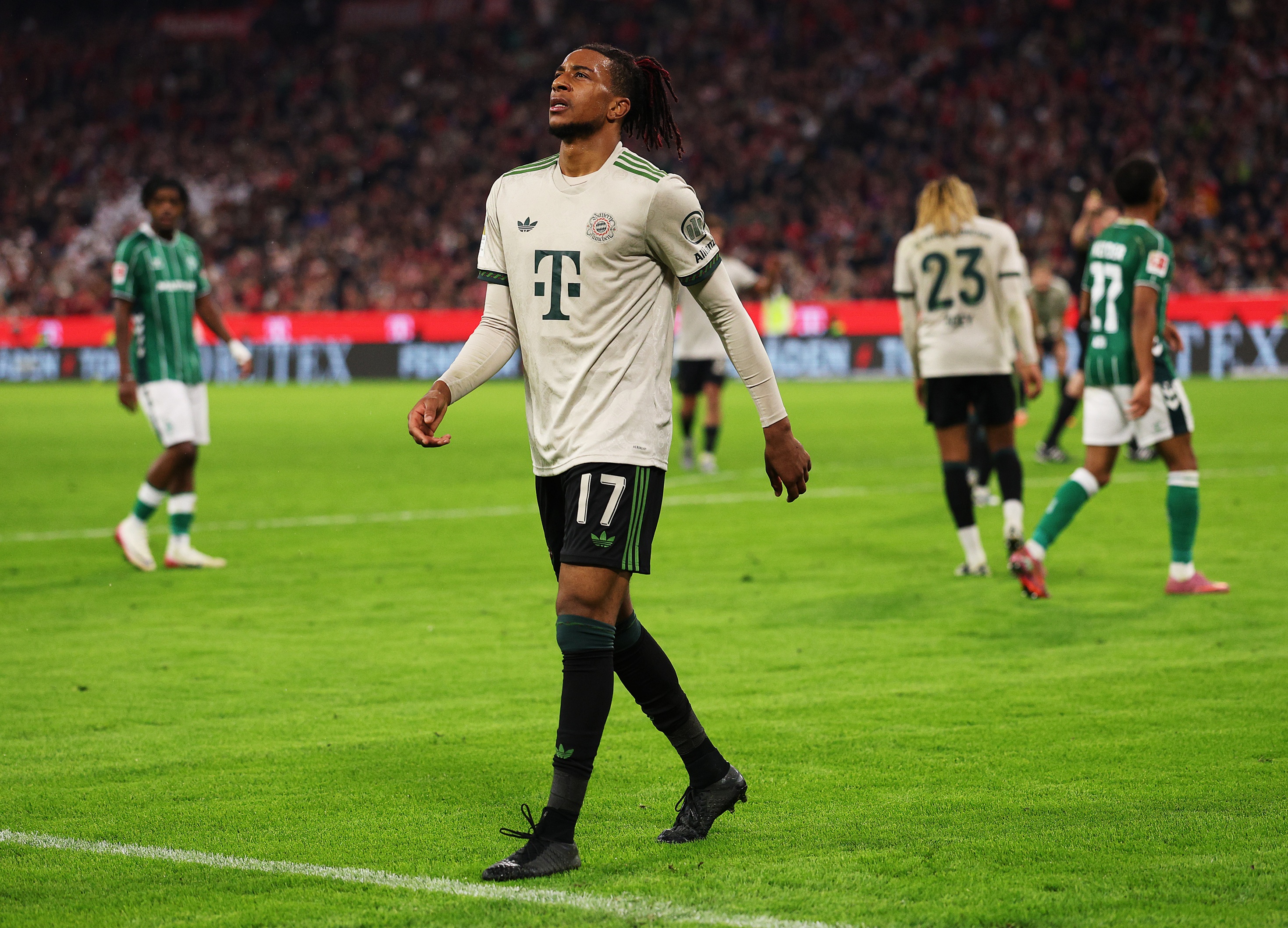Michael Olise walks on the pitch during Bayern Munich game.