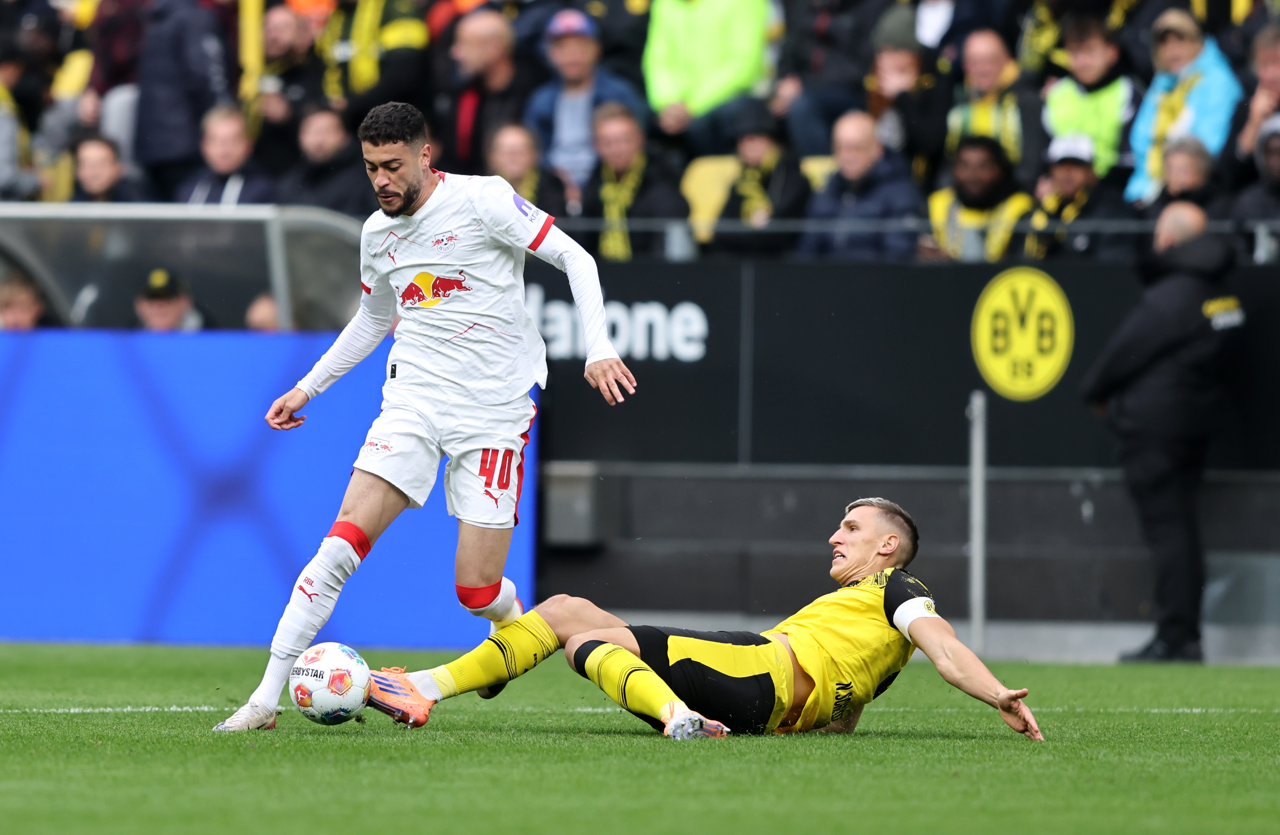 Nico Schlotterbeck goes to ground to tackle Romulo Cardoso.