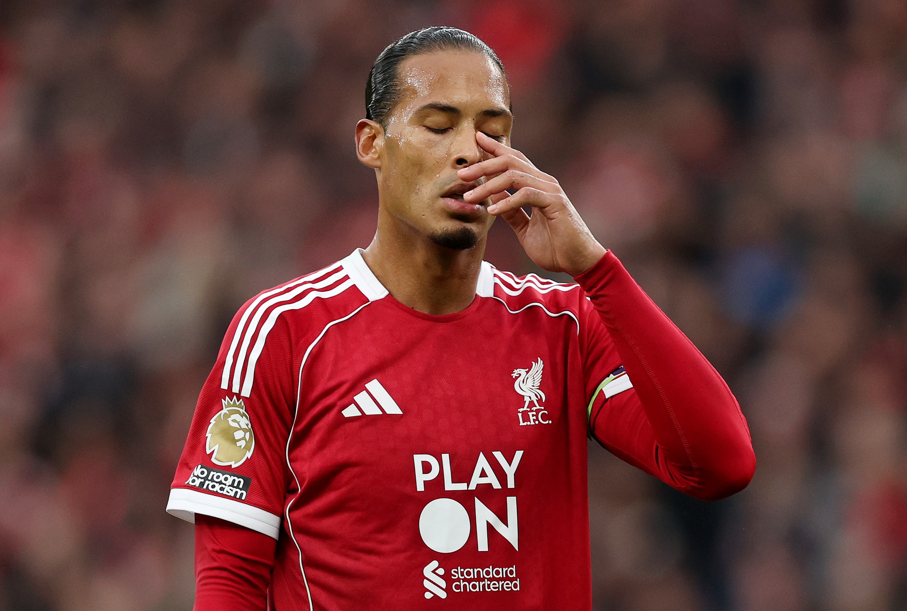 A frustrated Virgil van Dijk covers his face with his hand.