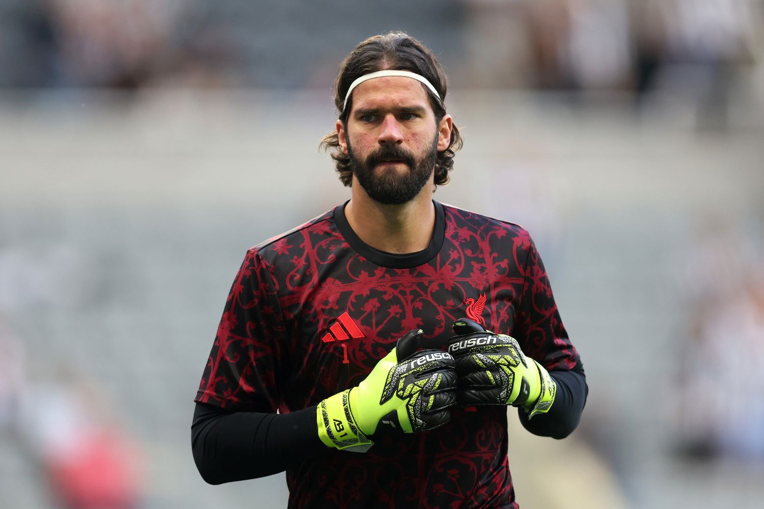 Alisson Becker warms up for Liverpool