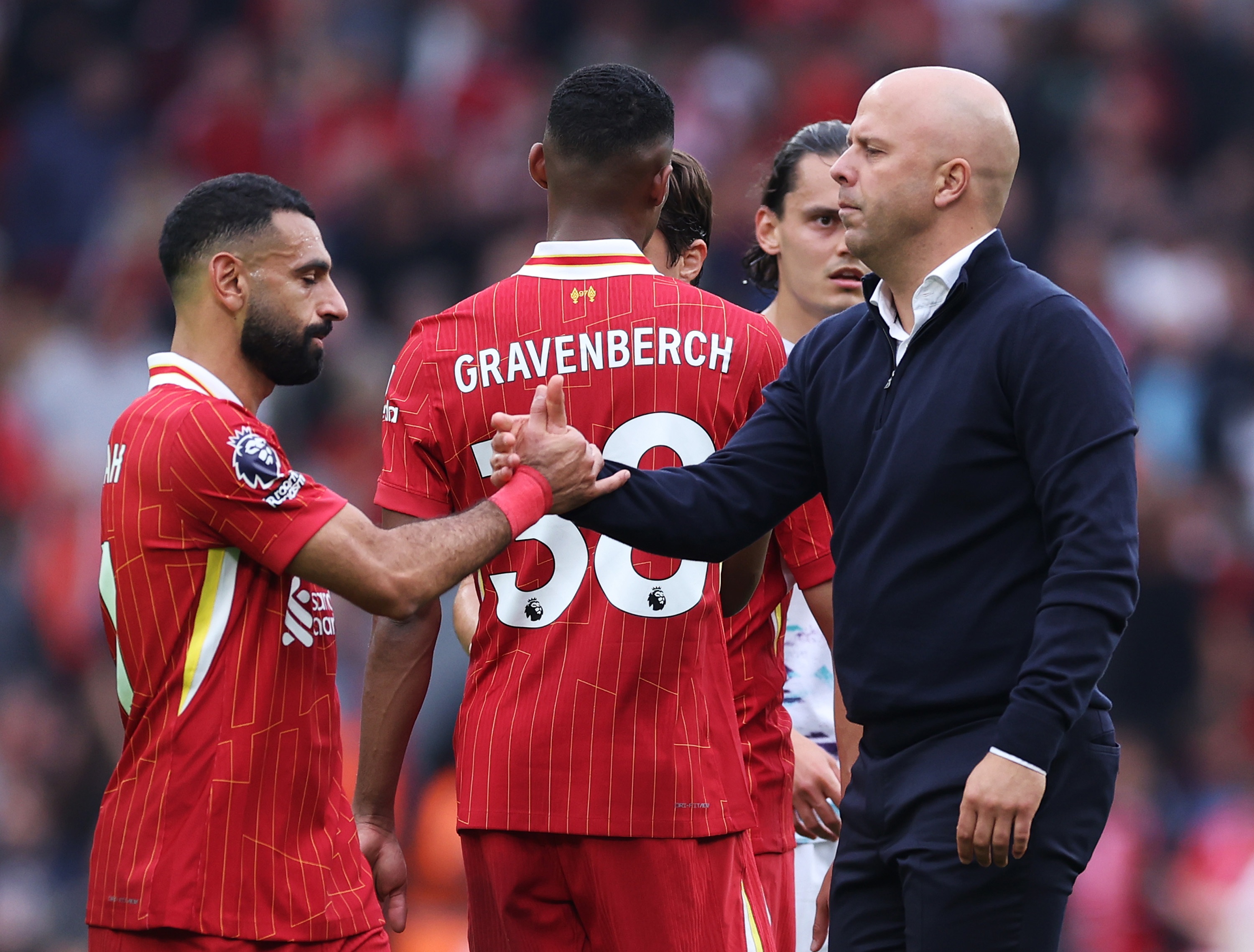 Mo Salah shakes hands with Liverpool head coach Arne Slot.