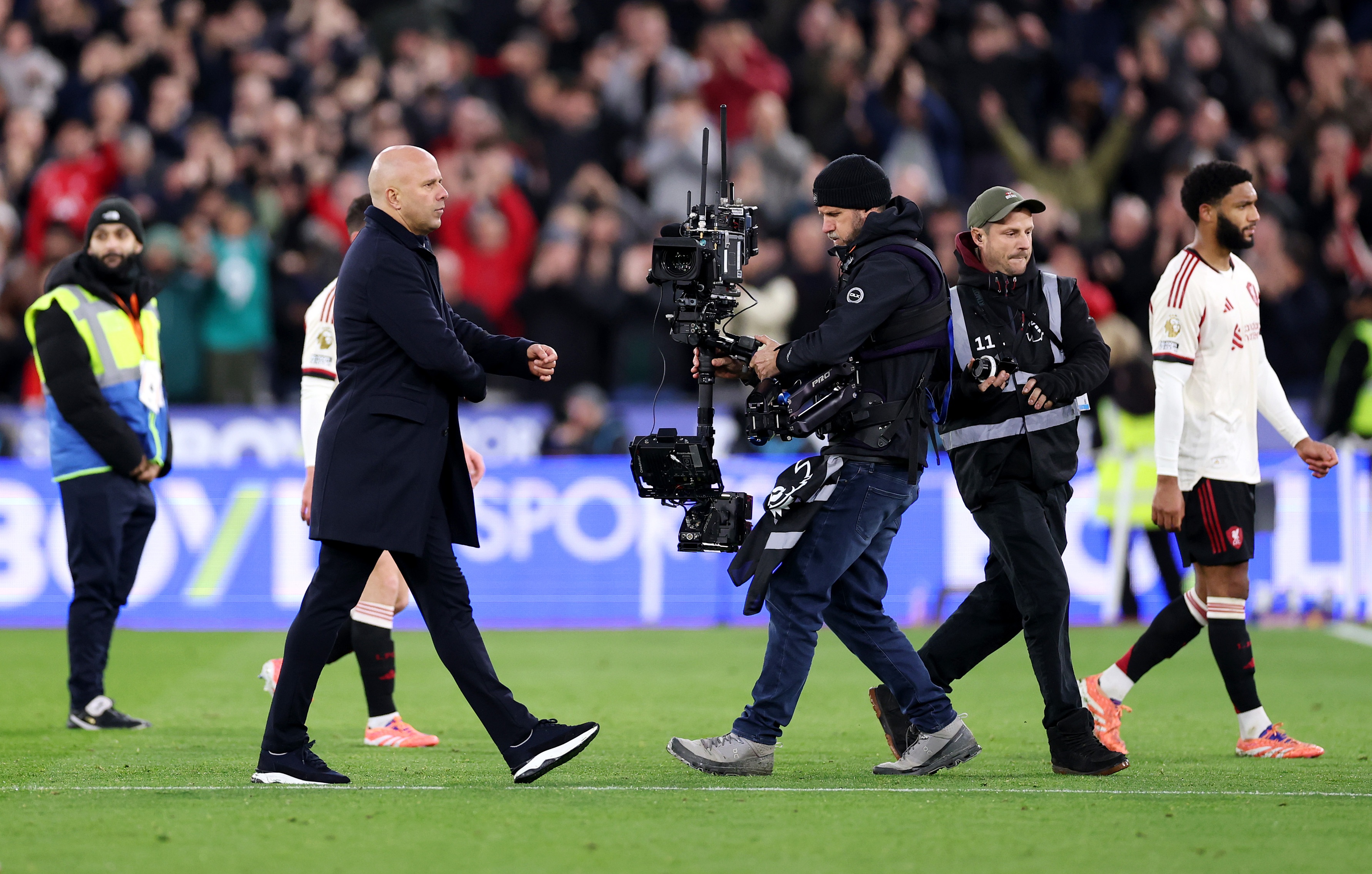 Cameraman tracks Arne Slot's movement on the pitch.
