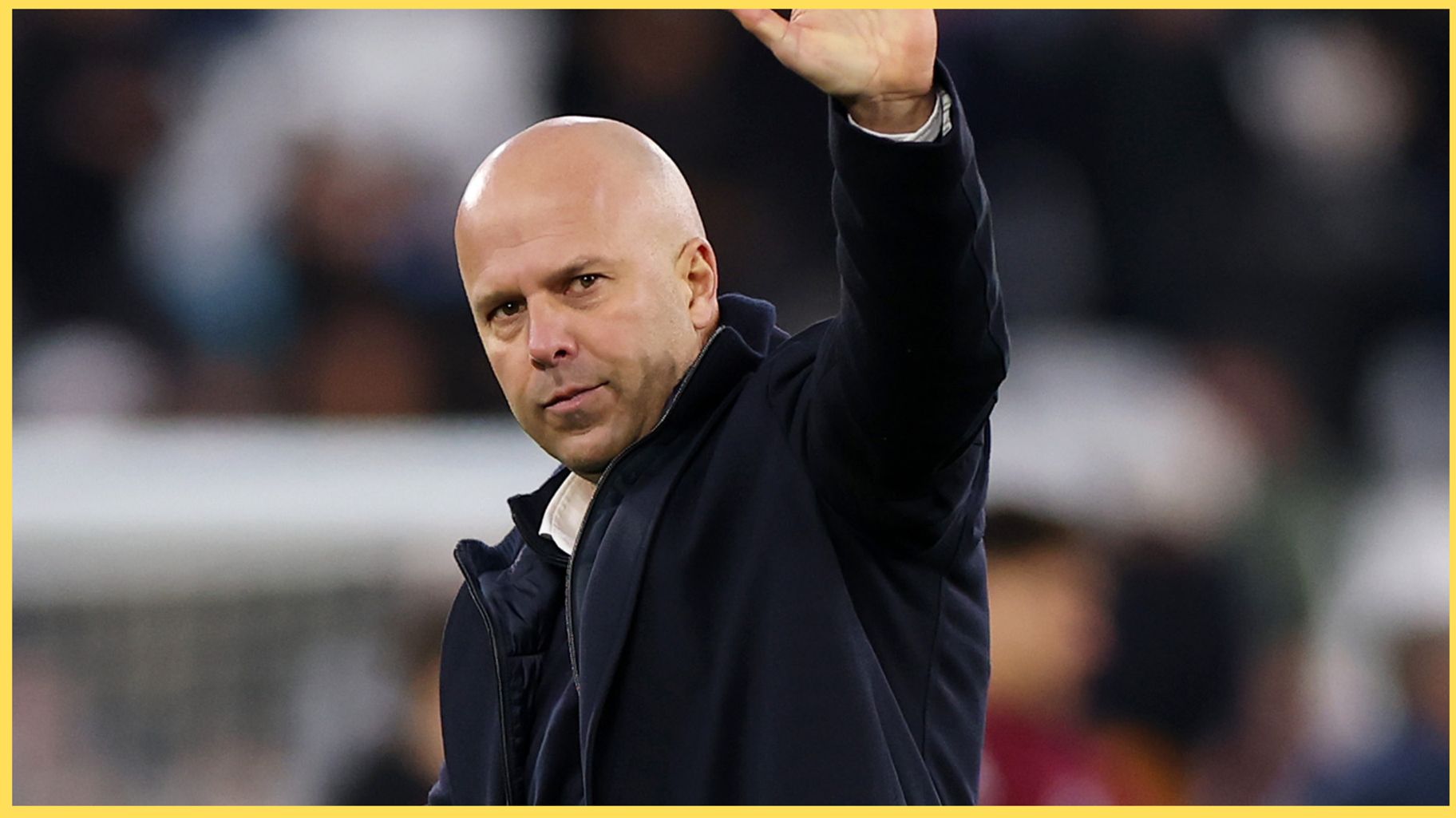 Arne Slot holds up his hand to acknowledge Liverpool fans.