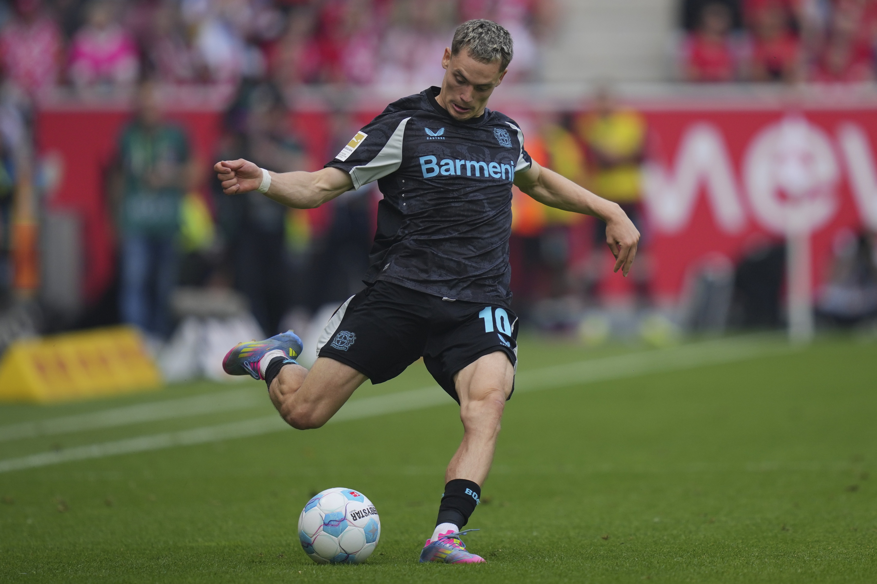 Florian Wirtz kicks a ball while playing for Bayer Leverkusen.