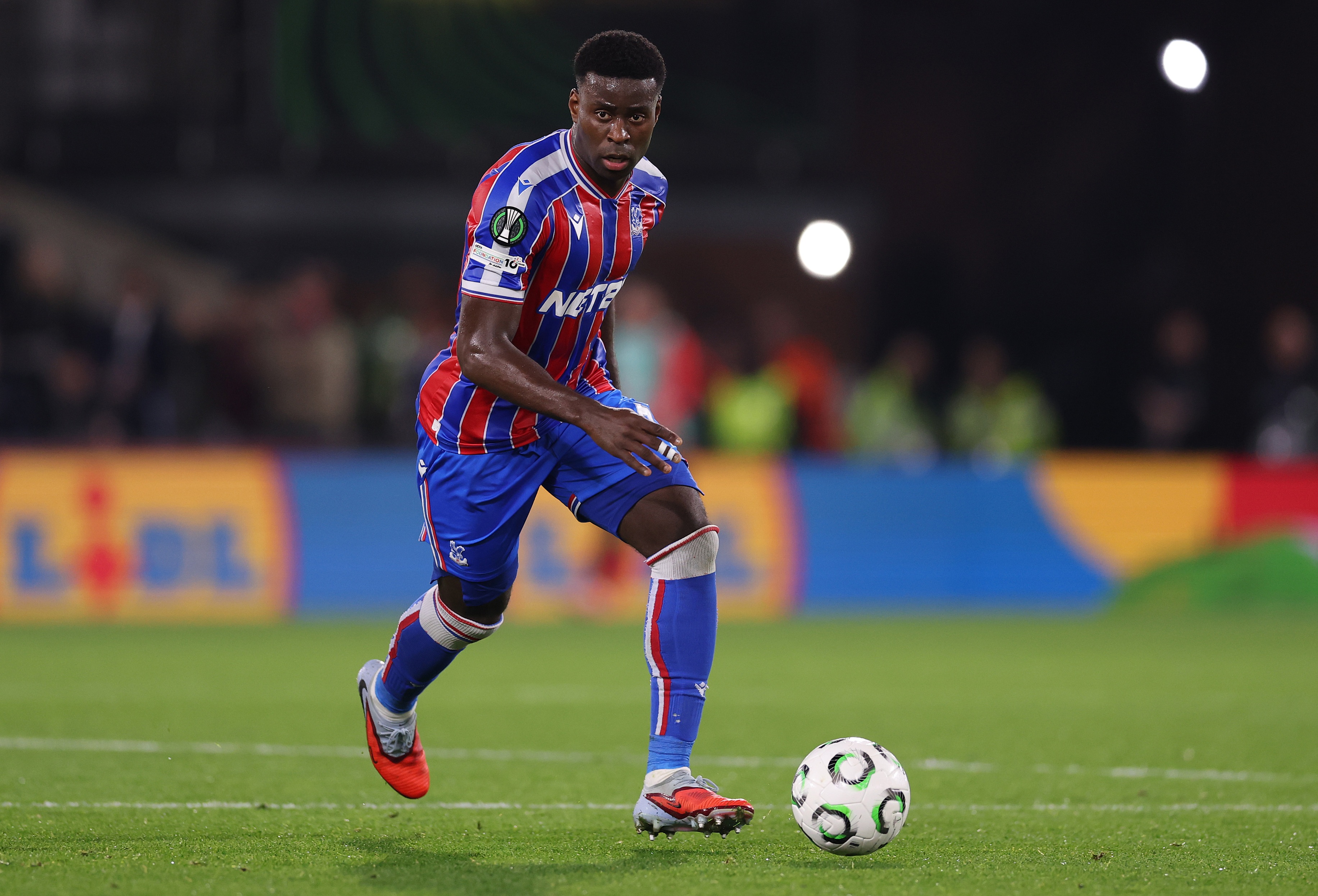 Marc Guehi runs with the ball during Crystal Palace game.