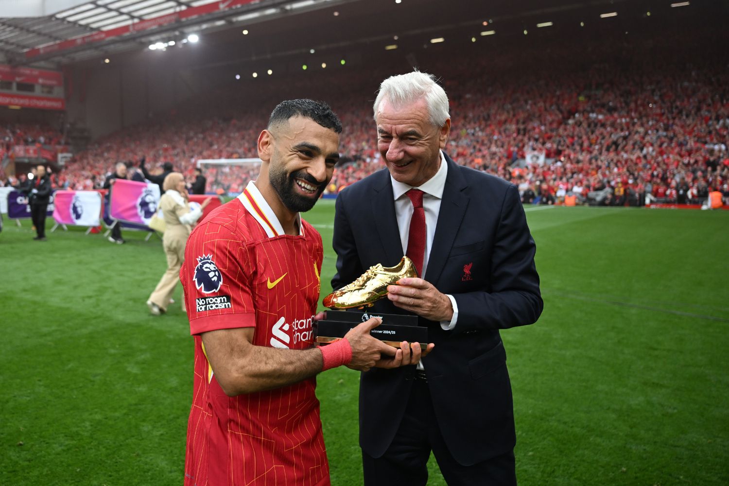 Mohamed Salah of Liverpool poses for a photograph as he is presented with the Premier League Golden Boot Winner 2024/25 Award trophy by former Liverpool player Ian Rush