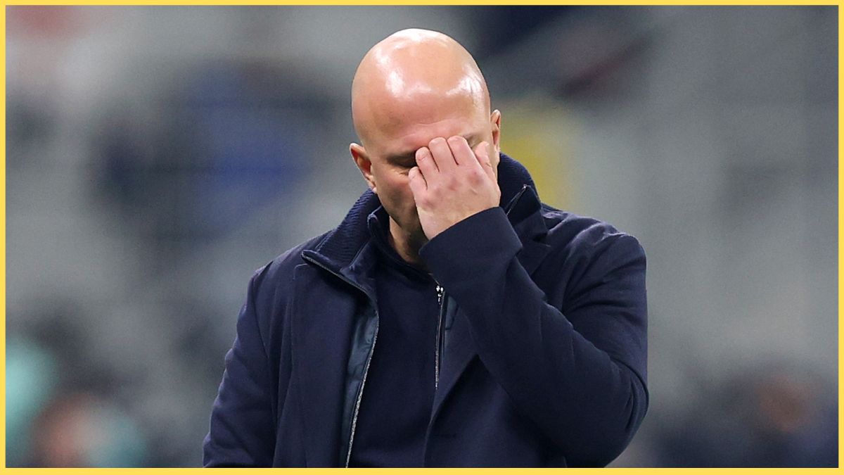 Arne Slot scratches his face at the San Siro.