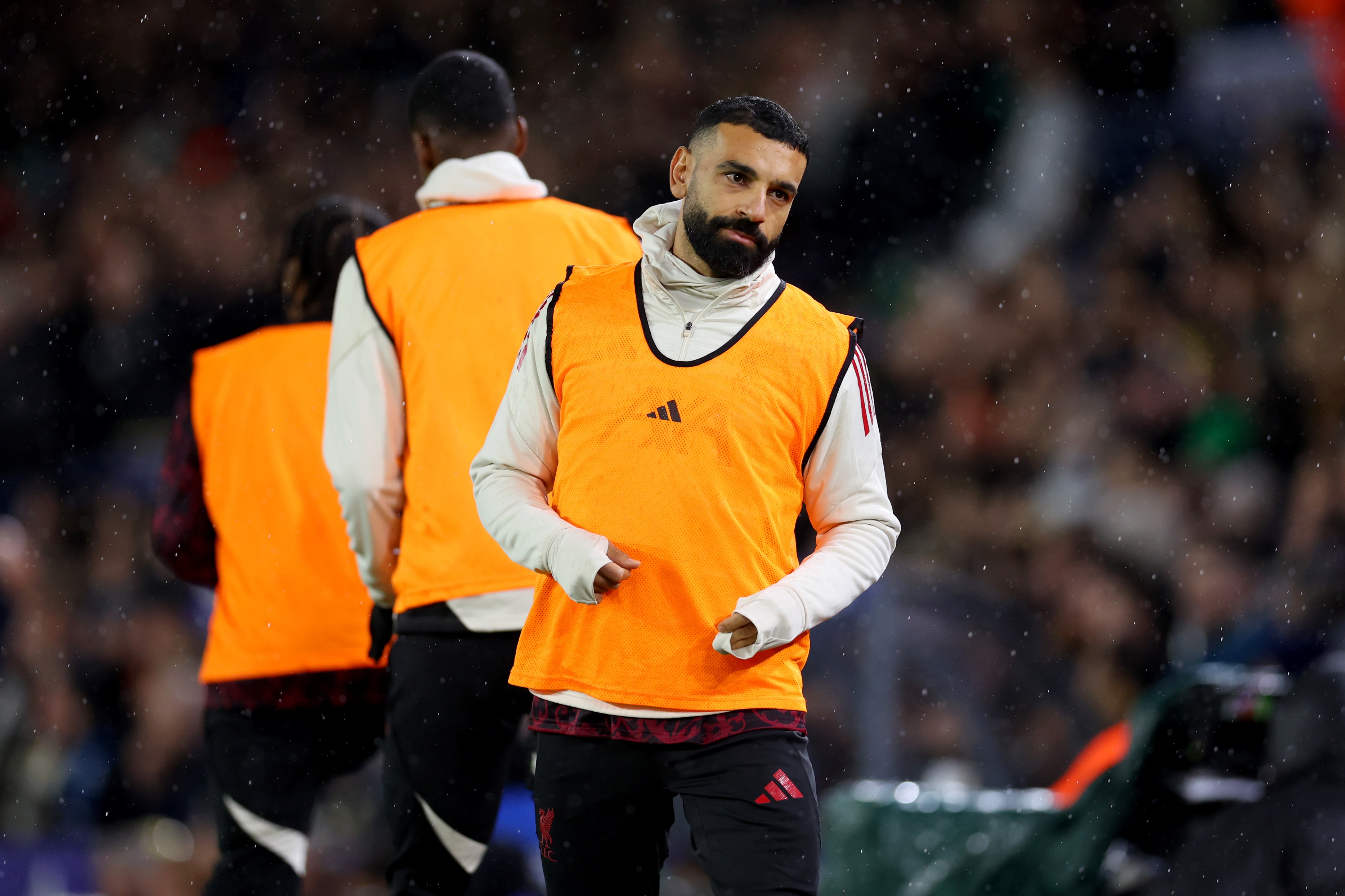 Mo Salah walks on the pitch in a substitute bib.