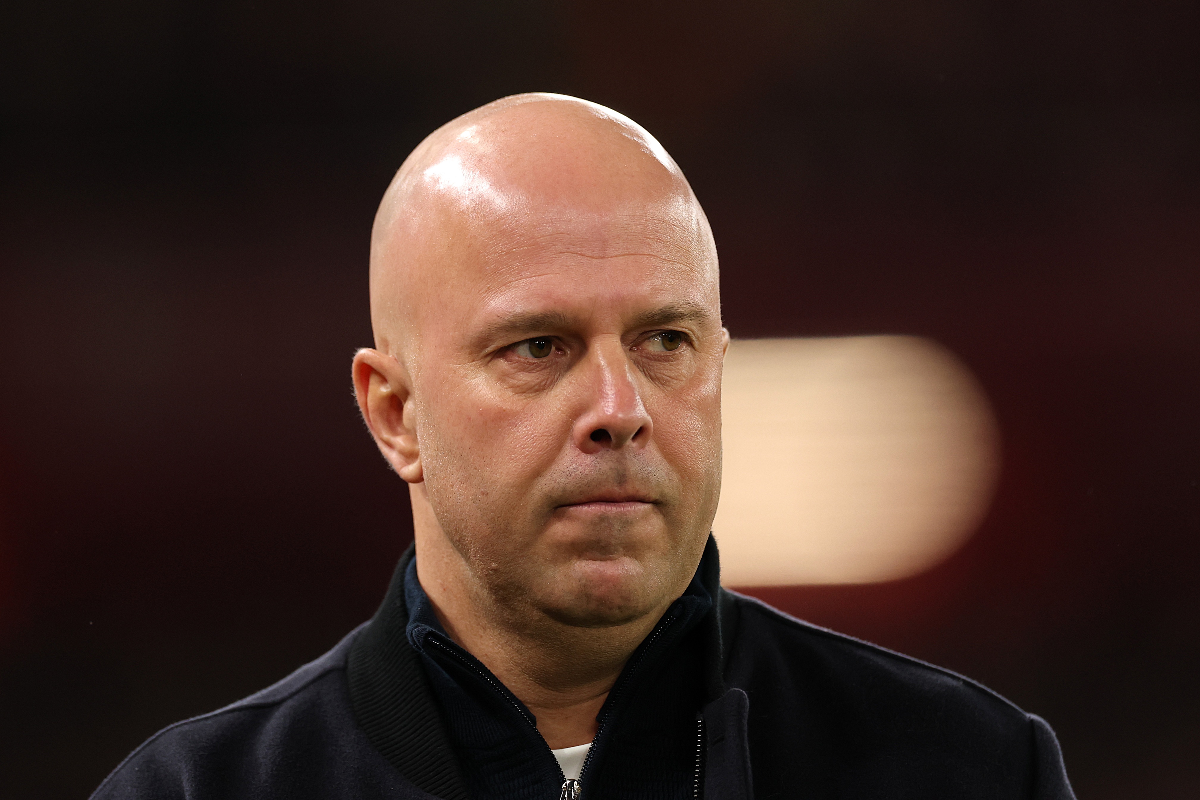 Arne Slot looks on with a neutral expression.