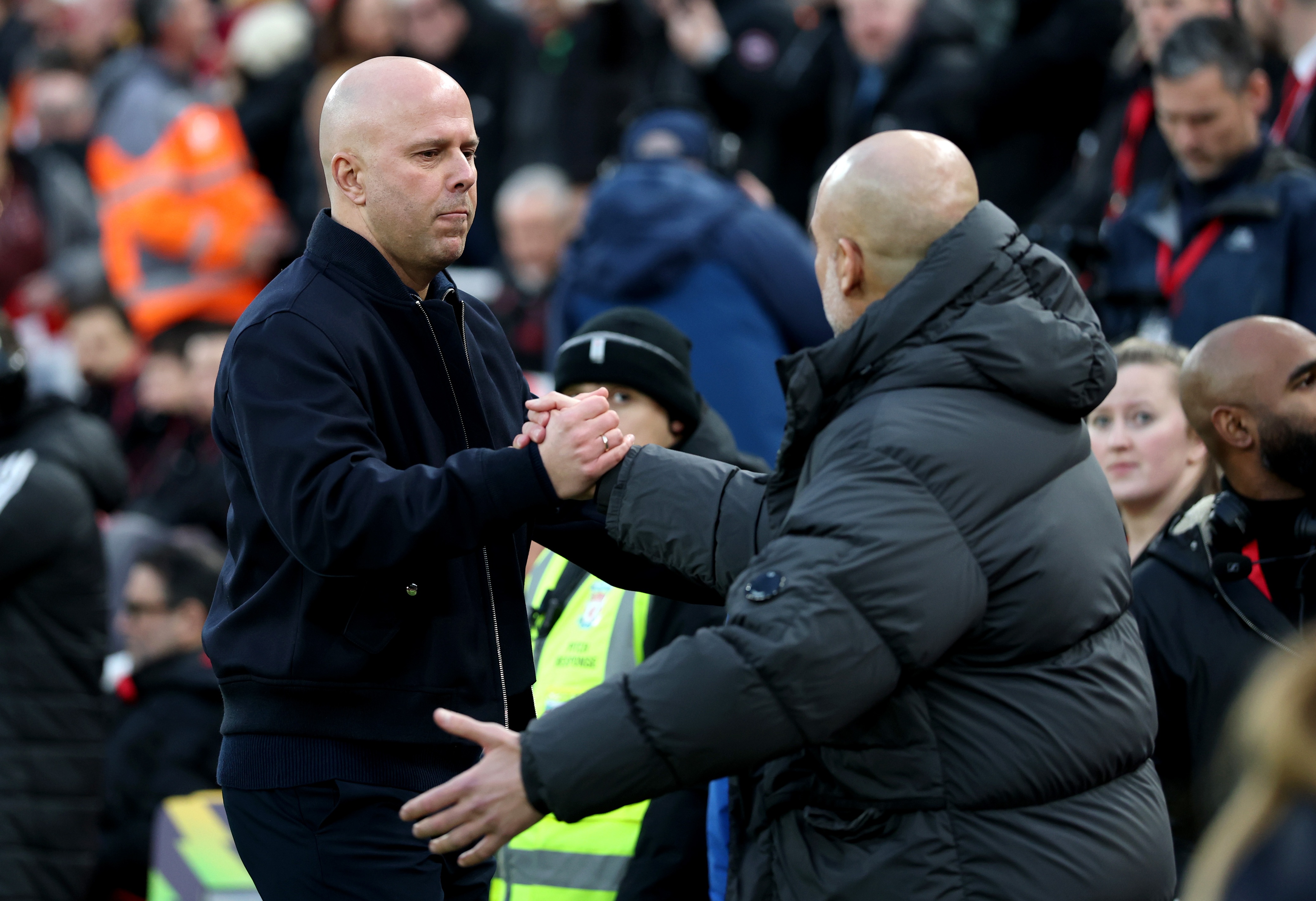 Arne Slot shakes hands with Man City head coach Pep Guardiola.