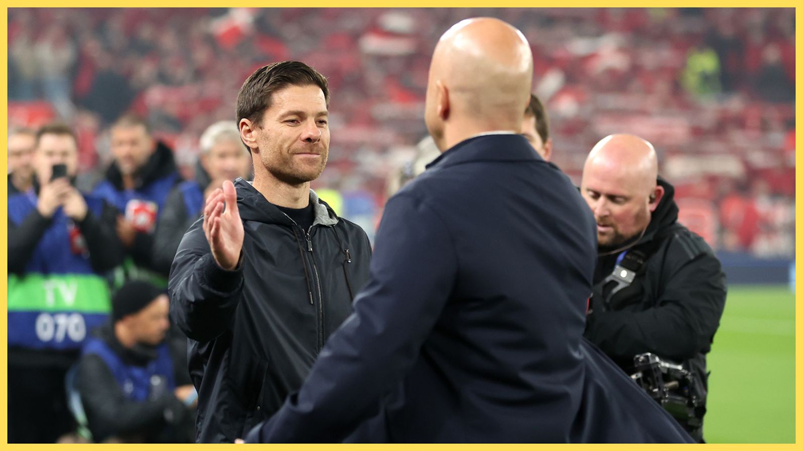 Xabi Alonso shakes hands with Liverpool head coach Arne Slot.