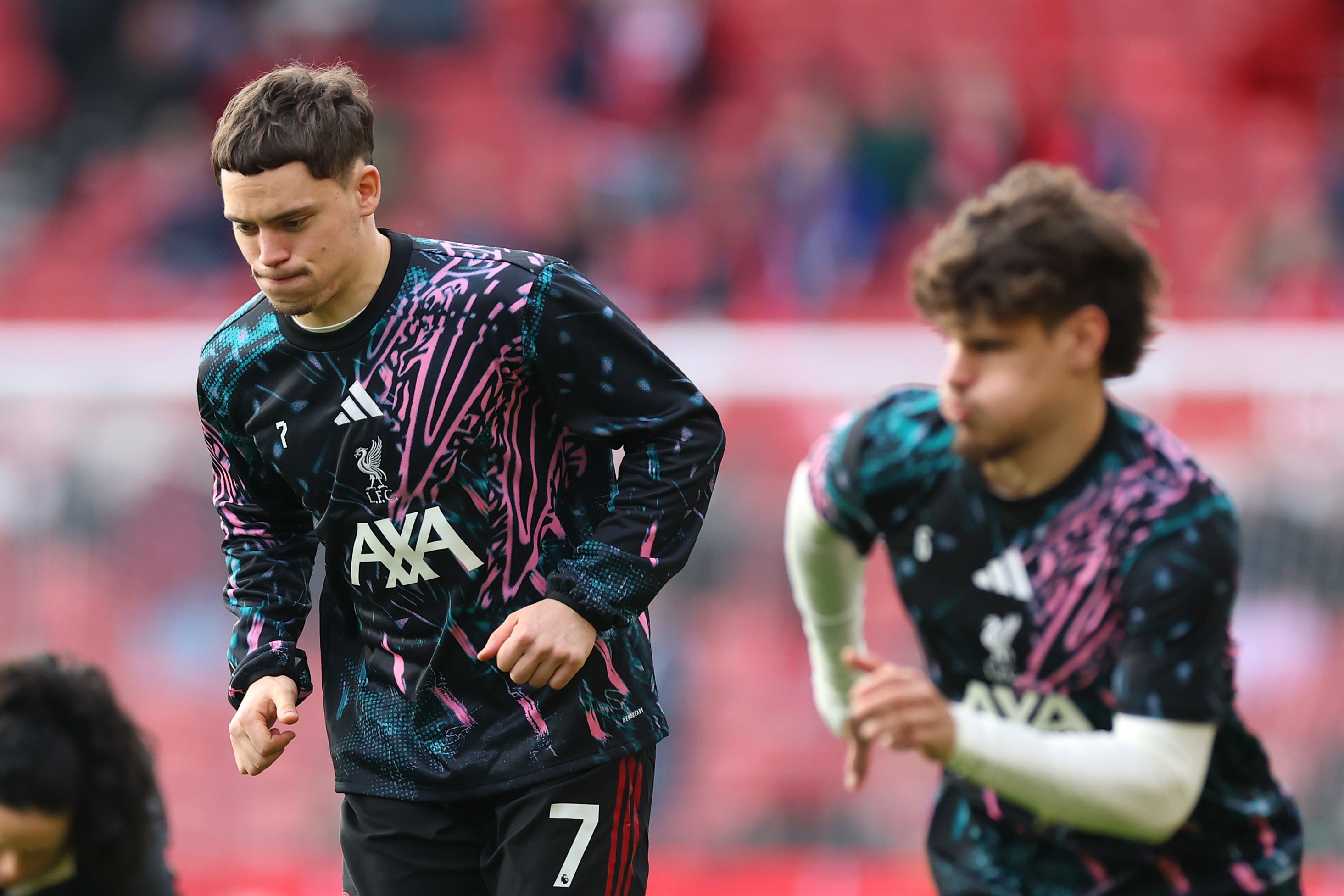 Florian Wirtz warms up alongside Liverpool fullback Milos Kerkez.