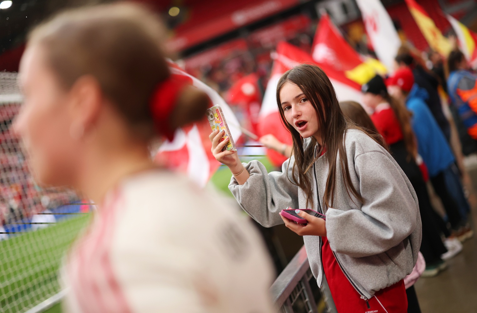 A Liverpool fan takes a photo on her smartphone before a match at Anfield