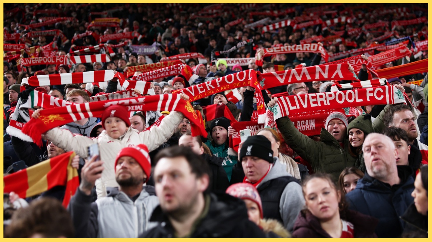 Liverpool fans hold scarves aloft while singing You'll Never Walk Alone