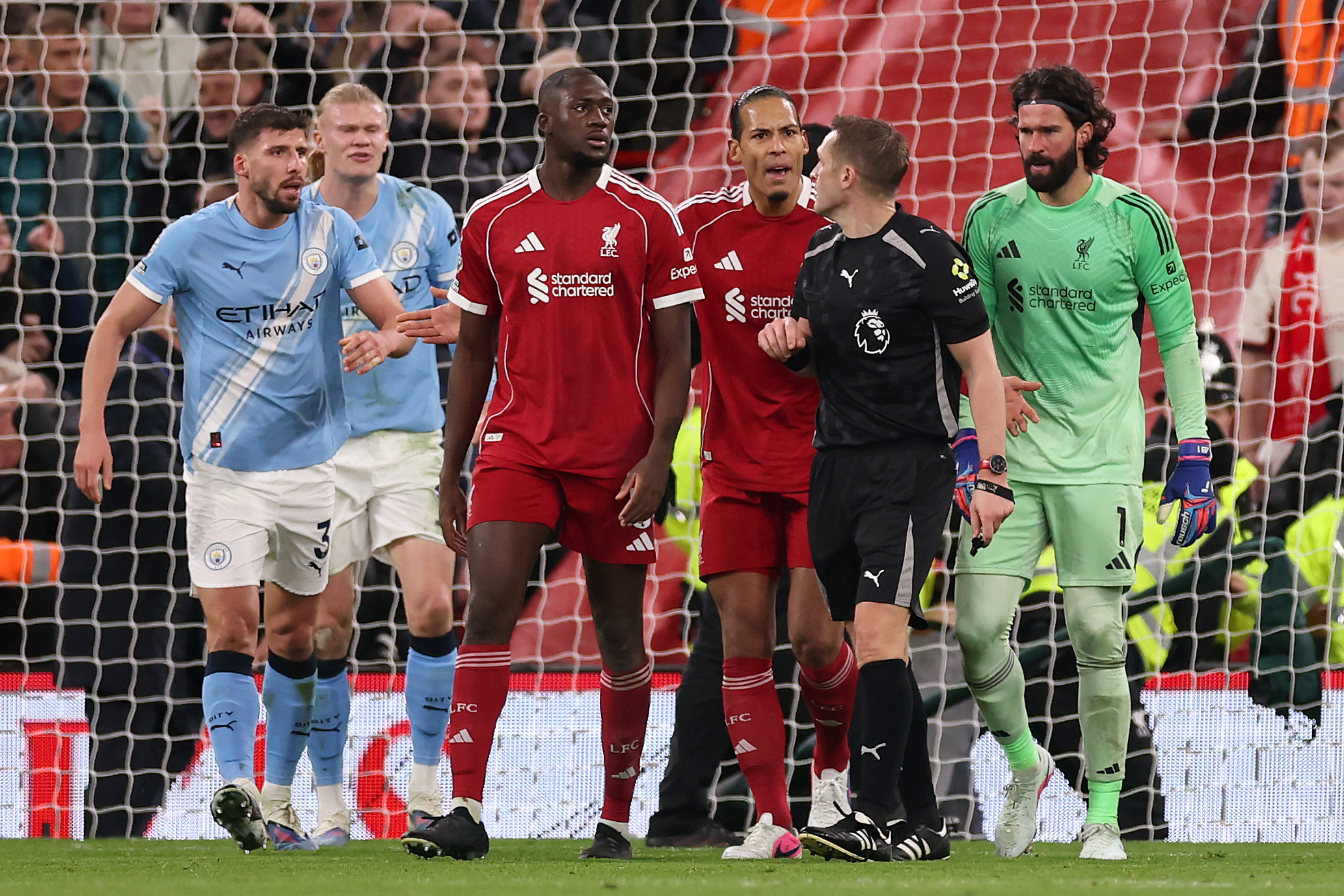Craig Pawson speaks with Liverpool and Man City players during the match at Anfield on Sunday