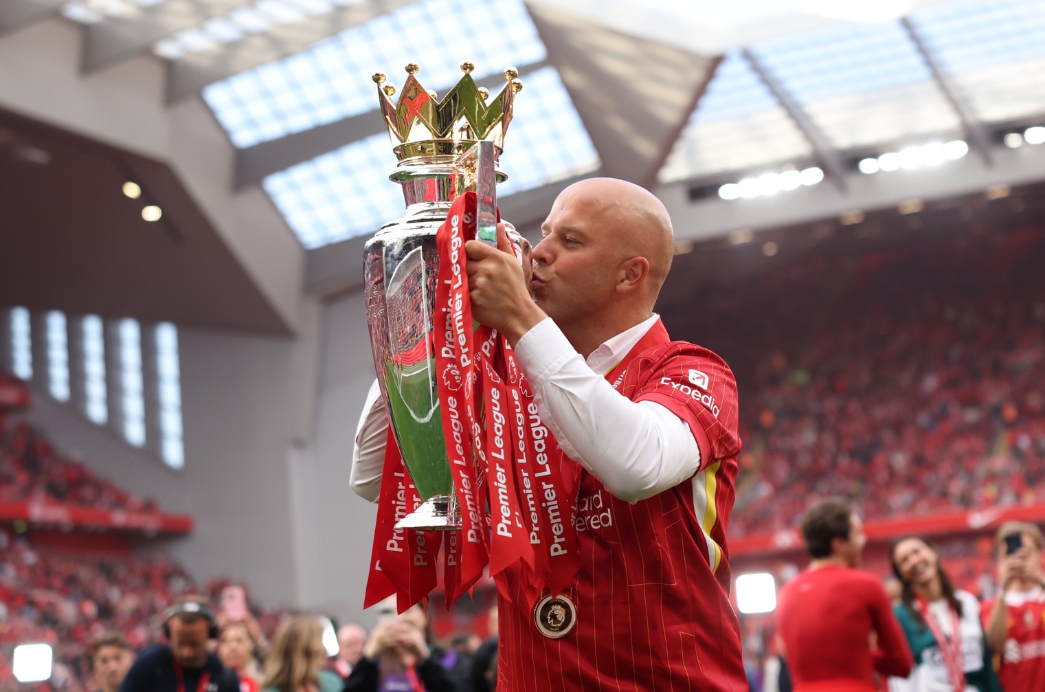 Arne Slot kisses the Premier League trophy that he won with Liverpool last season