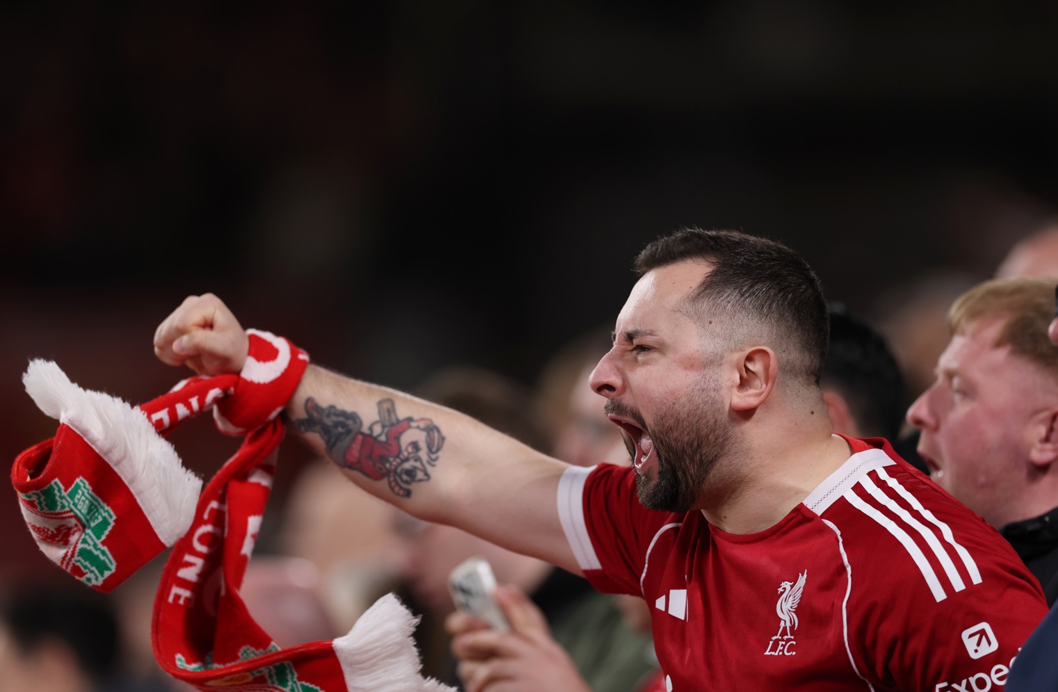 A Liverpool supporter roars on the Reds at Anfield