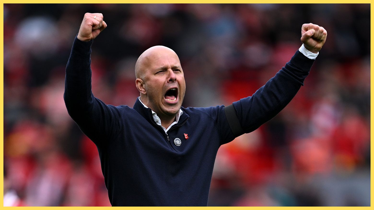 Arne Slot throws up his arms in celebration.