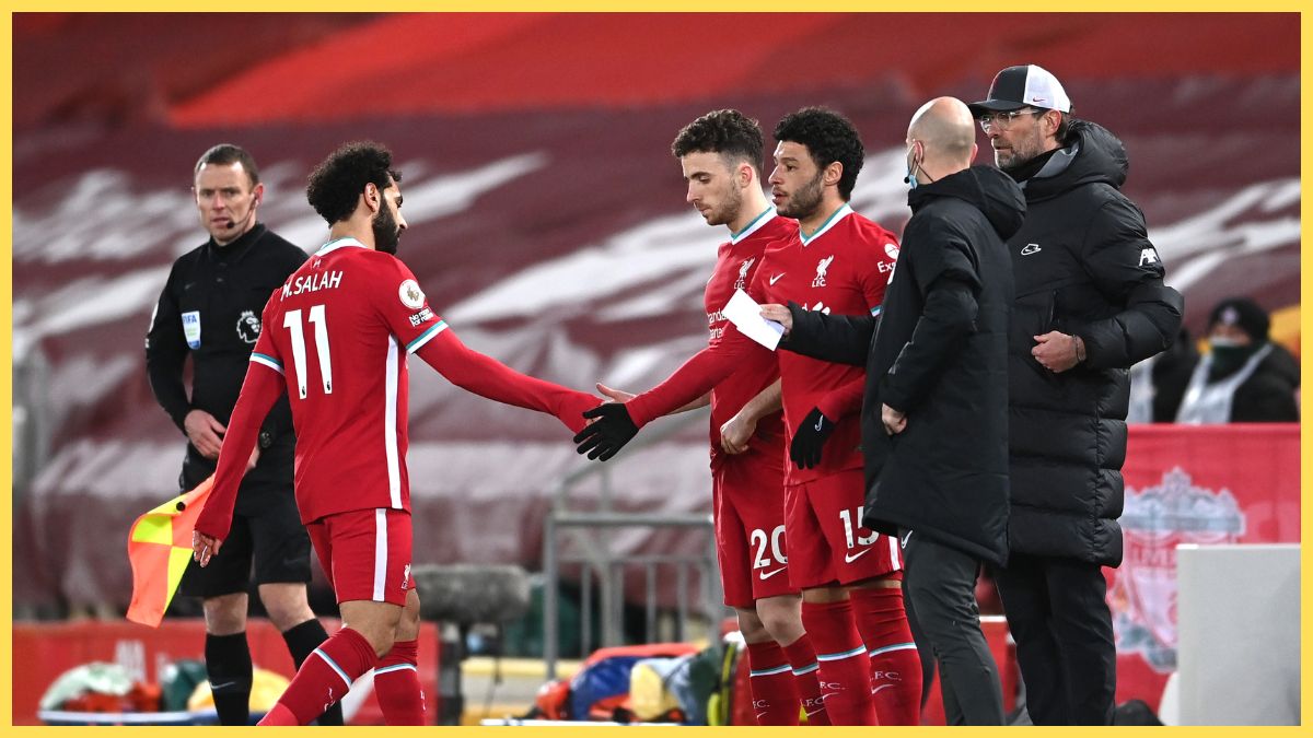 Mohamed Salah of Liverpool greets Diogo Jota of Liverpool as he is substituted off and Diogo Jota and Alex Oxlade-Chamberlain of Liverpool are substituted on during the Premier League match between Liverpool and Chelsea at Anfield
