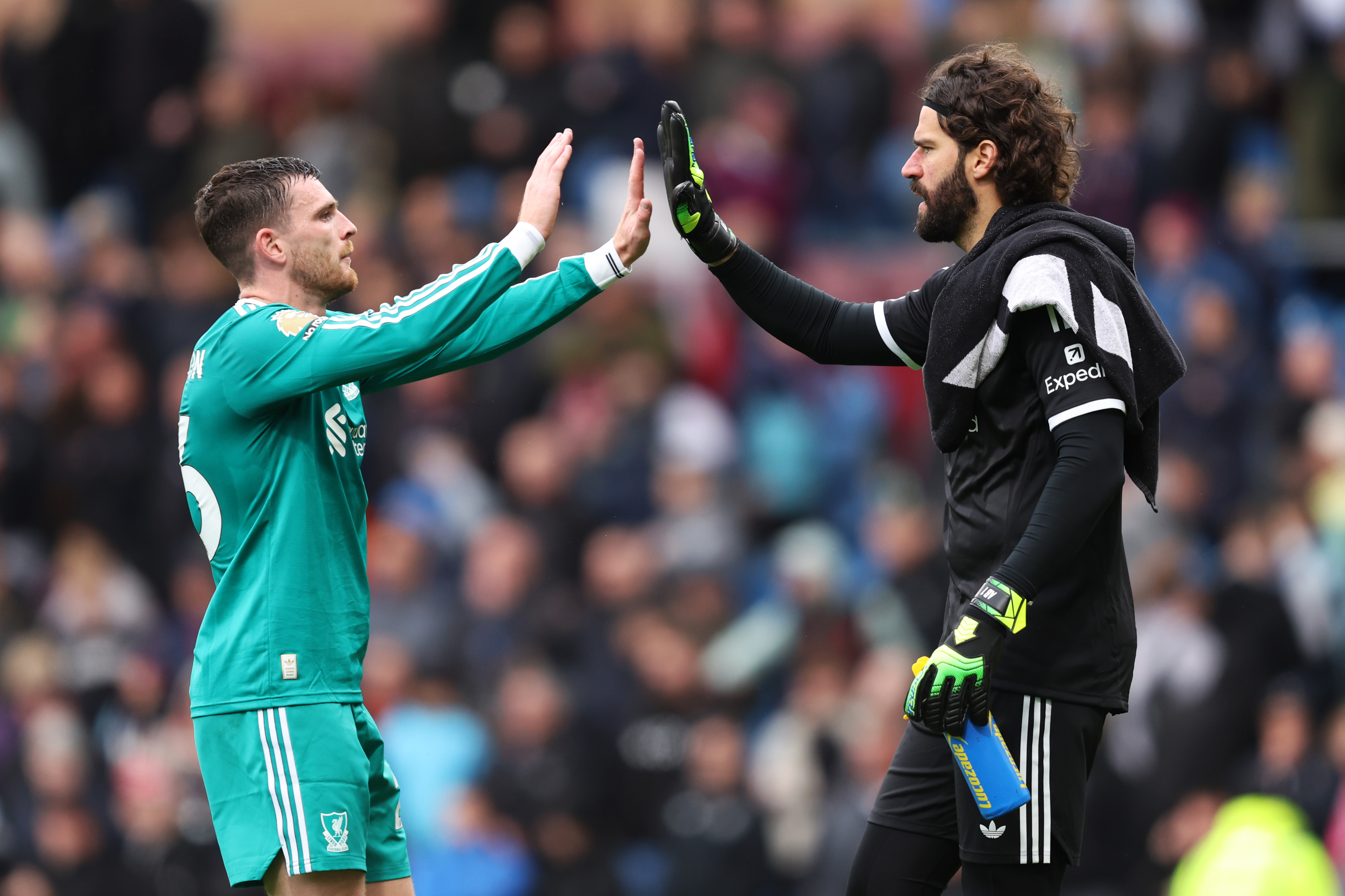 Andy Robertson and Alisson Becker high-five after a win for Liverpool