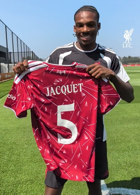 Jeremy Jacquet holds up his new number 5 shirt at Liverpool