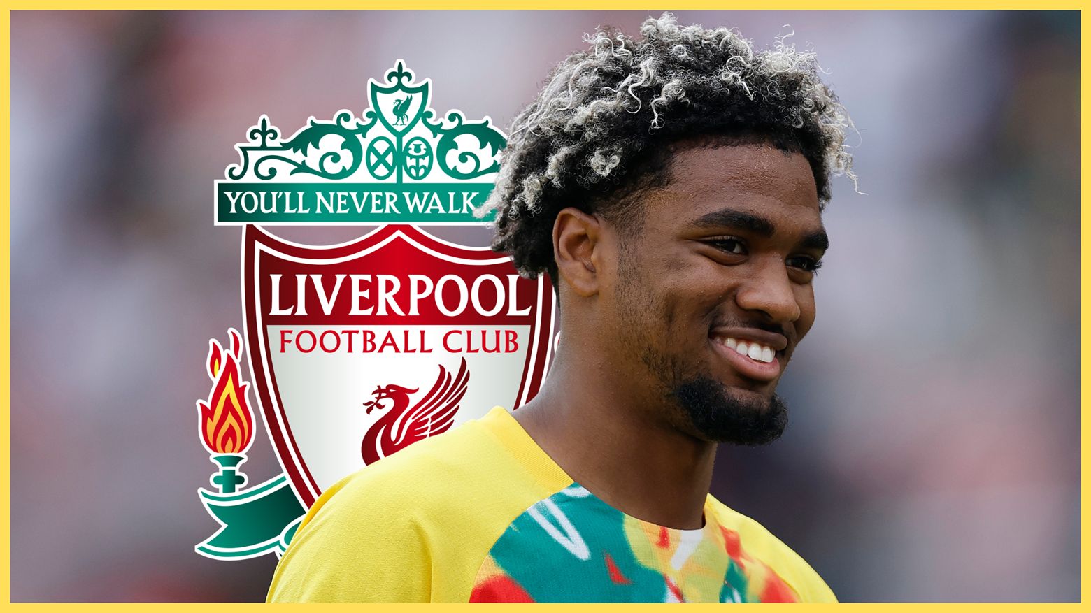 PSG winger Ibrahim Mbaye smiles in front of Liverpool club crest.