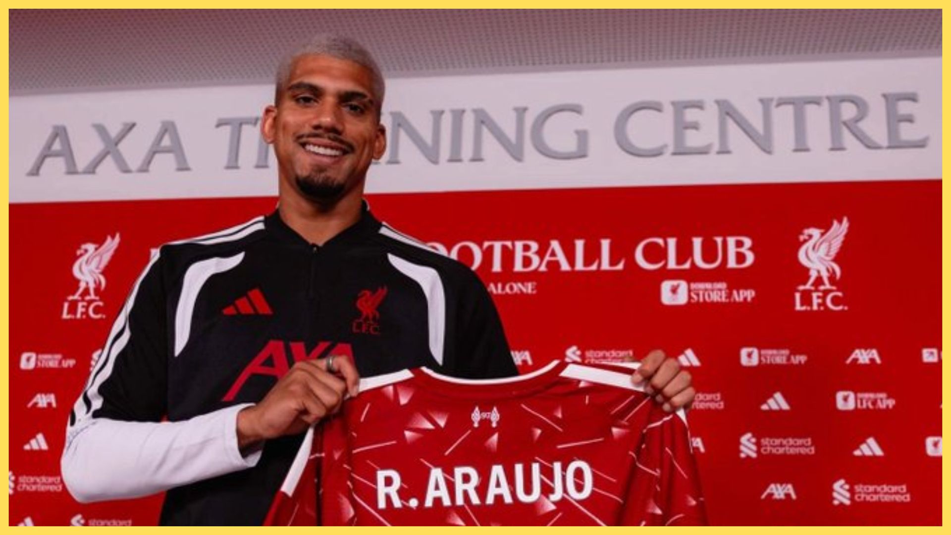 New Liverpool signing Ronald Araujo holds up a LFC shirt.